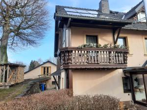a house with a balcony with flowers on it at Ferienwohnung Börner in Frauenstein