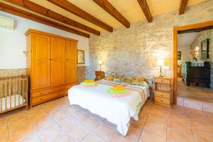 a bedroom with a bed and a stone wall at Can Sua in Artá +29 photos