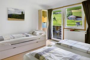 a bedroom with two beds and a window at Sport Rees - Ferienwohnung Melanie in Oberried