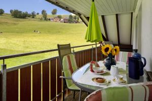 a table on a balcony with a view of a field at Sport Rees - Ferienwohnung Melanie in Oberried