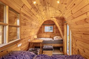 a room with two beds in a wooden cabin at Campingpod Auf Der Alpakawiese in Arnsberg