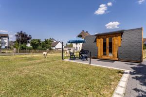 a small house with a patio and a yard at Campingpod Auf Der Alpakawiese in Arnsberg