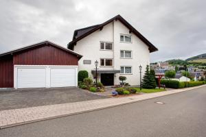 a large white house with a red garage at Haus Zur Laterne in Willingen