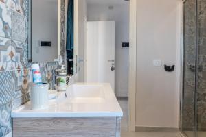a bathroom with a white sink and a mirror at Appartamento Le Primule in Agrigento +18 photos