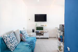 a living room with a blue couch and a tv at Appartamento Le Primule in Agrigento