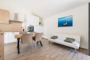 a kitchen and dining room with a table and a couch at Casa Vacanze Alba Mar in SantʼAntìoco