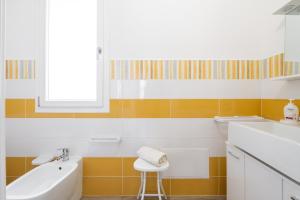 a bathroom with a sink and a toilet and a stool at Casa Vacanze Alba Mar in SantʼAntìoco
