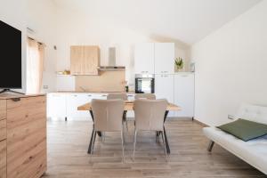 a kitchen and dining room with a wooden table and chairs at Casa Vacanze Alba Mar in SantʼAntìoco +18 photos