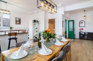 a dining room with a long table with glasses and flowers at Mäxle's Loft Winzeln in Winzeln +21 photos