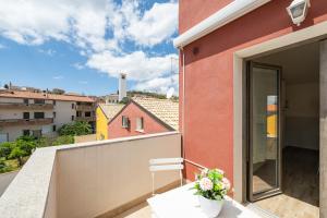 a balcony with a chair and a view of a building at Casa Vacanze Alba Mar in SantʼAntìoco