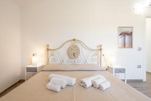 a bedroom with a bed with two towels on it at Casa Vacanze Alba Mar in SantʼAntìoco