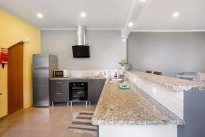 a kitchen with a counter top and a refrigerator at Casa Estrela Do Norte in Ponta Delgada