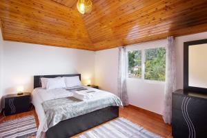 a bedroom with a bed and a window and a tv at Casa Estrela Do Norte in Ponta Delgada