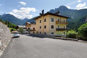 a house with a car parked on the side of a road at Affittacamere Angelina in San Pietro di Cadore