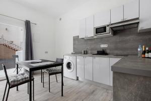 a kitchen with a table and a washing machine at La Corte A1 in Antigua +11 photos