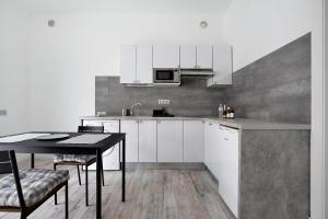 a kitchen with white cabinets and a table with chairs at La Corte A1 in Antigua
