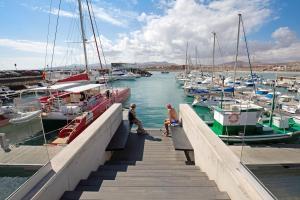 a group of people walking onto a dock with boats at La Corte A1 in Antigua