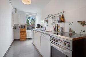 a kitchen with white cabinets and a stove top oven at Ferienwohnung Bett Und Buch in Lychen