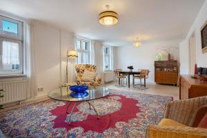 a living room with a glass table on a rug at Ferienwohnung Bett Und Buch in Lychen