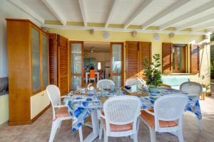 a dining room with a table and white chairs at Casa Donatella Torre dei Corsari in Torre Dei Corsari +20 photos