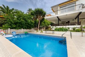 a swimming pool in front of a house at Oasis Salou Pool Beach and Bbq in Salou