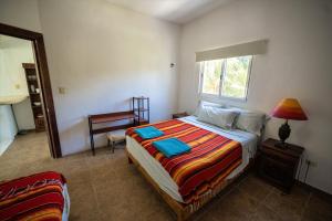 ein Schlafzimmer mit einem Bett, einem Fenster und einem Stuhl in der Unterkunft Casa Hokol Departamentos con Alberca in Telchac Puerto + 33 Fotos