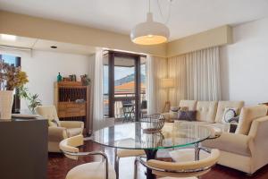 a living room with a glass table and chairs at Vista Formosa in Funchal