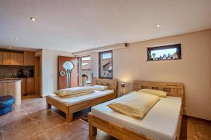 a bedroom with two beds and a kitchen at Haus am Bächel 2 in Obersasbach