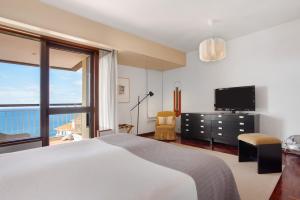 a bedroom with a bed and a large window at Vista Formosa in Funchal +23 photos