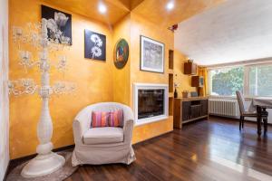 a living room with a white chair and a fireplace at Villa Lorenz in Putignano