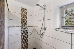a shower in a bathroom with white tiles at Blockhütte in Fürstenwalde +22 photos