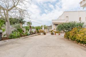 a driveway with plants and a white building at Casa Petros in Marsala