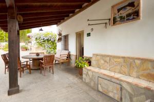 a patio with a table and chairs and a wall at La Acacia in Martos