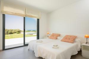 two beds in a white room with large windows at Villa Canutells Ref 27 in Mahón +35 photos