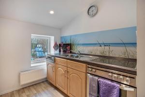 a kitchen with a sink and a clock on the wall at Wohnung Obergeschoss in Funfseen