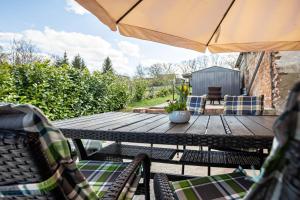 a patio with a table and chairs and an umbrella at Wohnung Obergeschoss in Funfseen