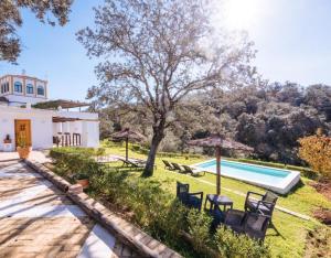 an external view of a villa with a swimming pool at Finca Gorriones 25 minutos Sevilla in El Garrobo