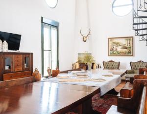 a dining room with a table and a couch at Finca Gorriones 25 minutos Sevilla in El Garrobo