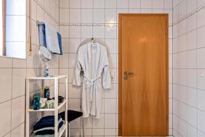 a bathroom with a robe hanging on a wall at Ferienwohnung Matt in Todtmoos +17 photos