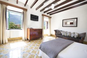 a bedroom with a bed and a couch and a television at Villa Rae in Sóller +23 photos
