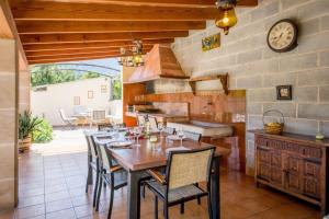 a kitchen with a table and chairs and a clock at Villa Rae in Sóller