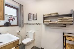 a white bathroom with a toilet and a sink at Marla in Lauterbach +16 photos