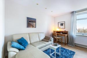 a living room with a white couch and a table at Haevn Erholung,Wattenmeer &Wäldchen in Reußenköge