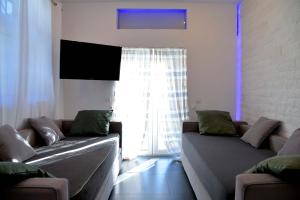 a living room with two couches in front of a window at Doliva Studio with private pool in Agios Gordios