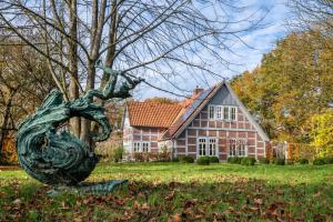 a statue in front of a large house at Landhaus im Garten in Hude