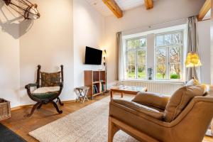 a living room with a couch and a chair at Landhaus im Garten in Hude