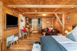 a room with a bed and a tv and a living room at Chalet Bergliebe mit Zirbenholz in Inzell