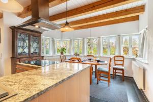 a kitchen with wooden ceilings and a table and chairs at Landhaus im Garten in Hude