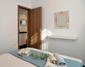 a bedroom with a bed with towels and a mirror at Doliva Studio with private pool in Agios Gordios +34 photos
