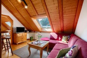 a living room with a purple couch and a table at Haus Schlageter in Dachsberg im Schwarzwald